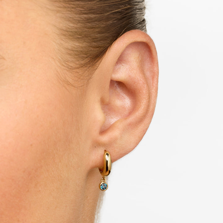 Blue Topaz Round Drop Charm Huggie Earrings in Gold